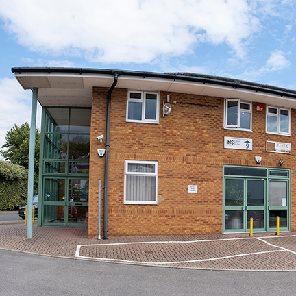 The brick exterior shot of the Challenge enterprise centre with green and white window frames