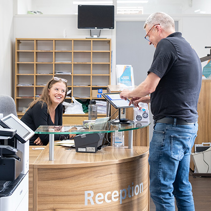 Image of a Reception area with a man asking the receptionist a question