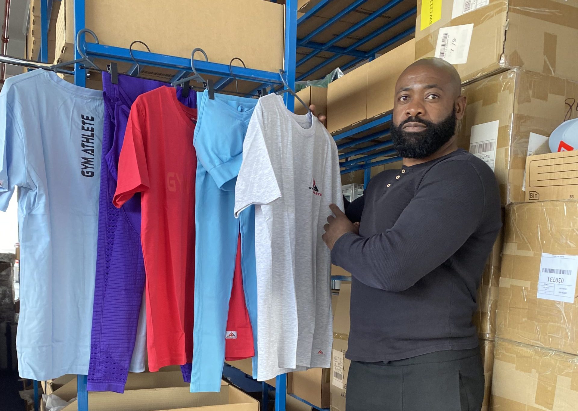 Business owner standing in unit with Gym Athlete clothing